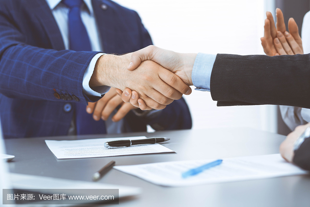 商人們握手,完成一份文件簽名。會議、合同及律師咨詢理念